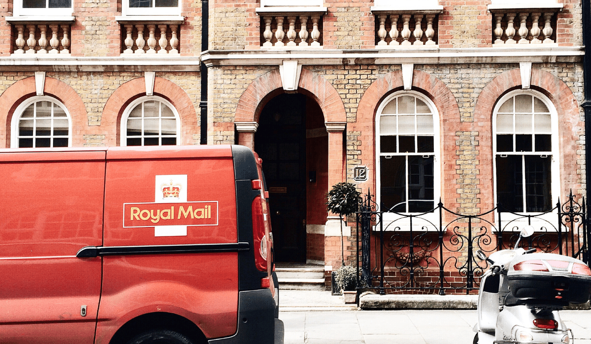 a royal mail postal van parked outside a brick home address to delivery a package