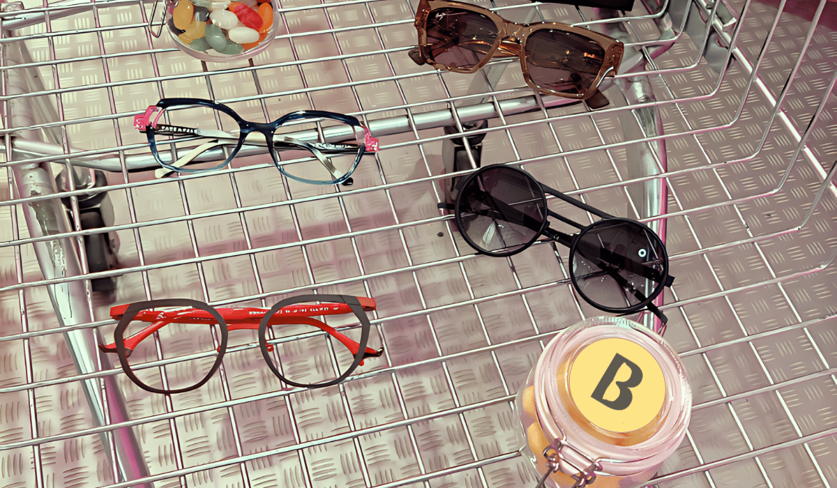 a shopping trolly with 4 pairs of glasses and two jars of sweets with the blackheath eyecare logo on them