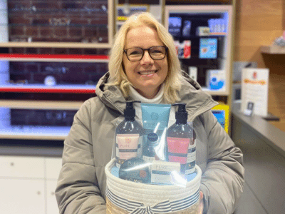 A female blackheath eyecare client smiling whilst holding her skincare raffle prize