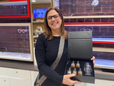 a female smiling holding a wiskey tasting gift prize