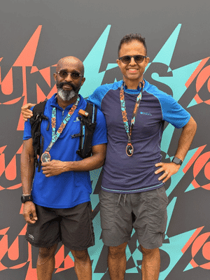 Two male participants of the 2025 London half marathon happy posing proudly with their completion medals