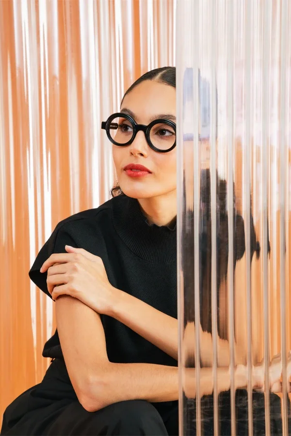 Woman wearing round black Anne et Valentin optical frames